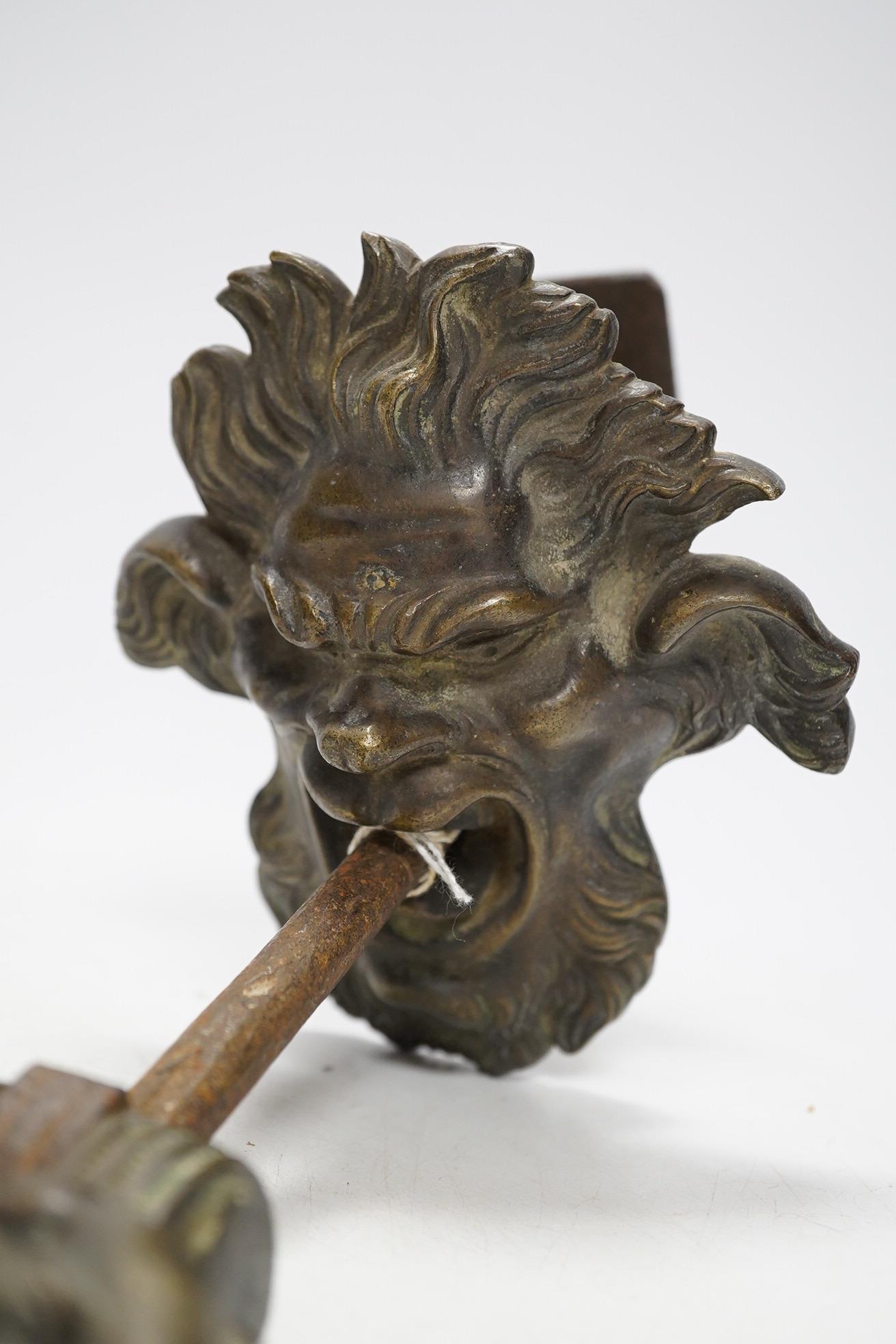 An Italian bronze satyr door knocker, circa 1700, together with a brass handle, knocker drop 22cm. Condition - fair